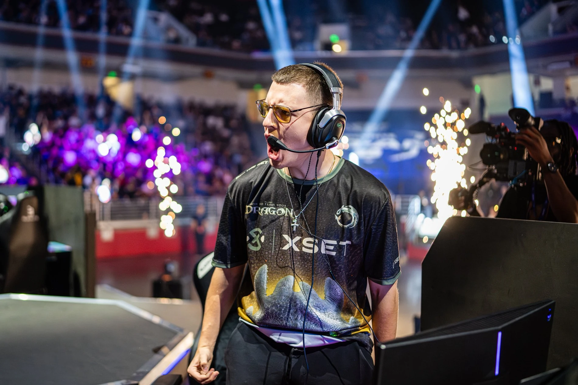 Clix competing on stage, wearing his headset and XSET jersey
