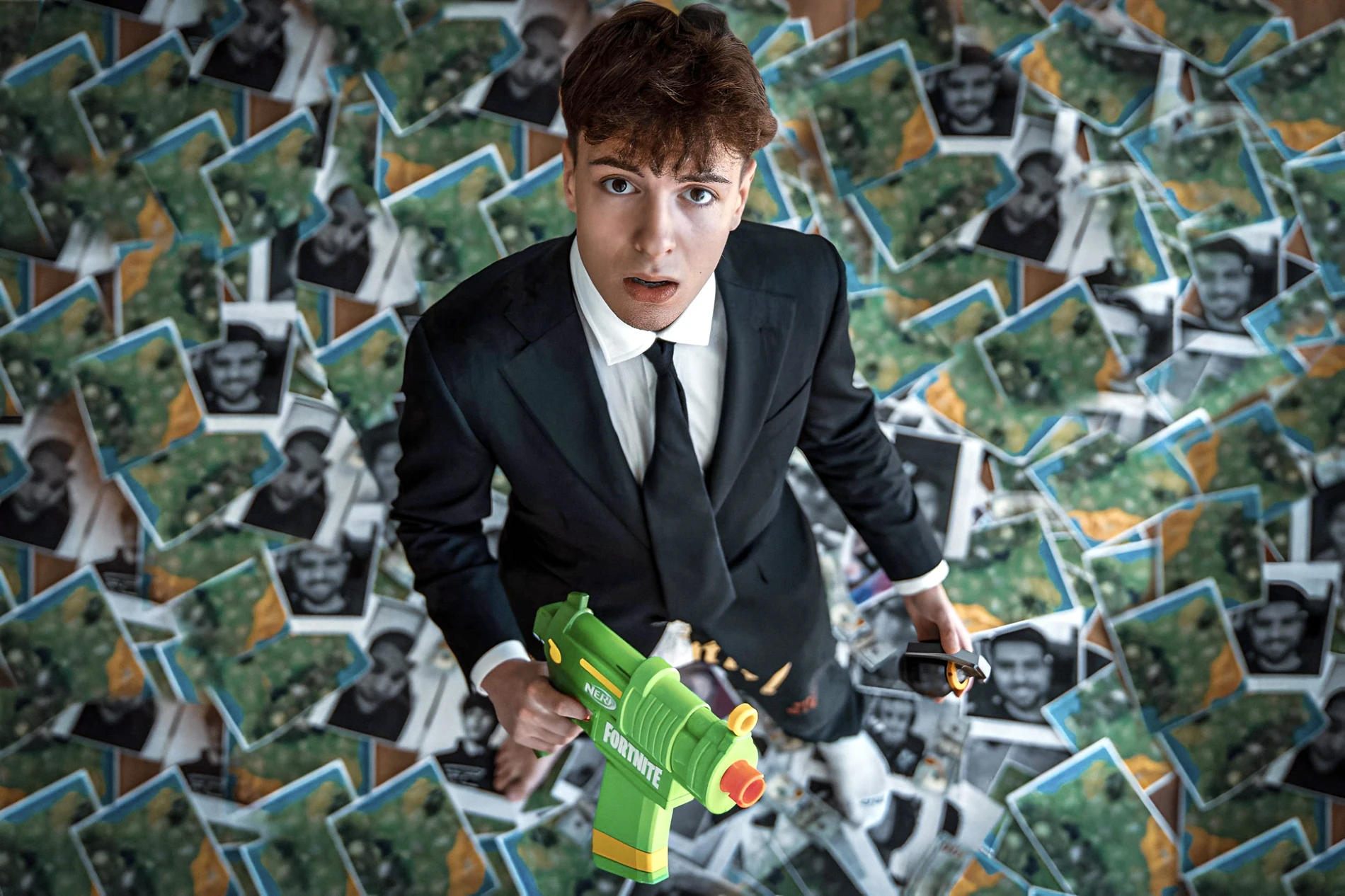 Clix in a suit with a green Fortnite Nerf blaster, photographed from above